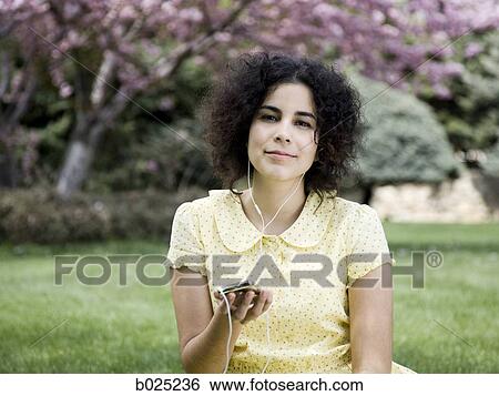 woman in a yellow dress listening to music View Large Photo Image Stock Photograph - woman in a yellow dress listening to music. Fotosearch