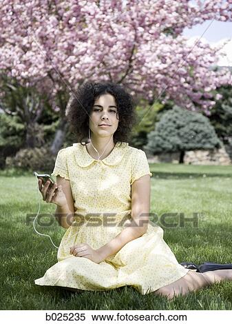 woman in a yellow dress listening to music View Large Photo Image Stock Photography - woman in a yellow dress listening to music. Fotosearch