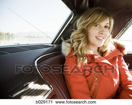 Stock Image - woman in the back seat of a classic car. Fotosearch