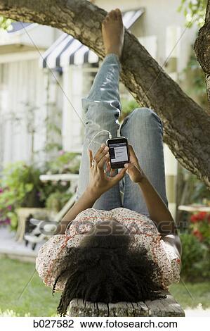 woman in the backyard listening to a digital music player View Large Photo Image Stock Image - woman in the backyard listening to a digital music player. Fotosearch