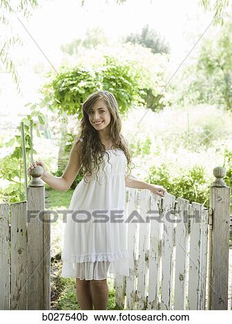 Stock Image - woman in the garden in a summer dress. Fotosearch
