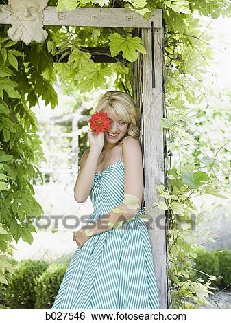 Stock Photograph - woman in the garden in a summer dress. Fotosearch