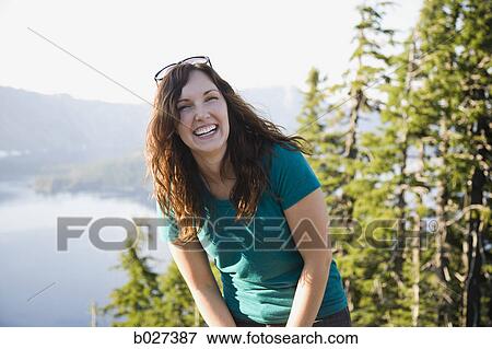 woman laughing in the forest overlooking a lake View Large Photo Image Stock Photo - woman laughing in the forest overlooking a lake. Fotosearch