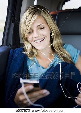 Stock Image - woman listening to music on a car ride. Fotosearch