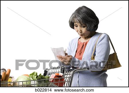 Picture - woman looking at a shopping list. Fotosearch