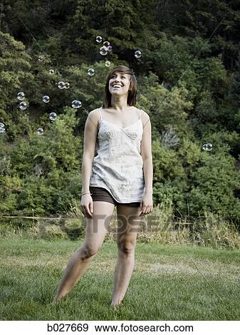 Stock Photo - woman looking at bubbles. Fotosearch