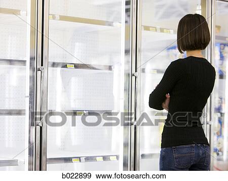 woman looking into empty refrigerators at market View Large Photo Image Stock Photo - woman looking into empty refrigerators at market. Fotosearch