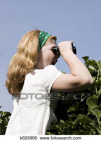 woman looking over a hedge with binoculars View Large Photo Image Stock Photography - woman looking over a hedge with binoculars. Fotosearch