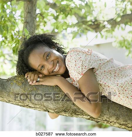 woman lying down on a tree branch View Large Photo Image Stock Photo - woman lying down on a tree branch. Fotosearch