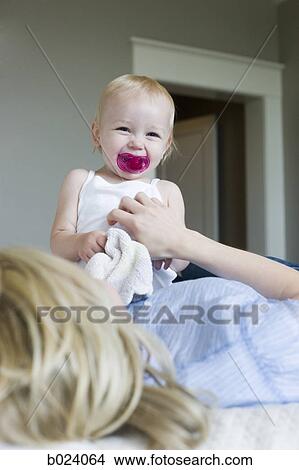 woman lying on a bed with her baby girl View Large Photo Image Picture - woman lying on a bed with her baby girl. Fotosearch