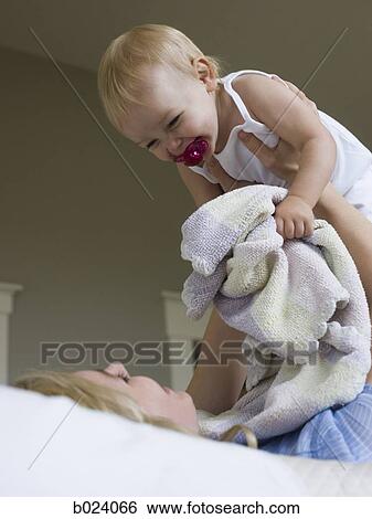 woman lying on a bed with her baby girl View Large Photo Image Stock Photograph - woman lying on a bed with her baby girl. Fotosearch