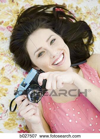Stock Photo - woman lying on a floral print blanket. Fotosearch