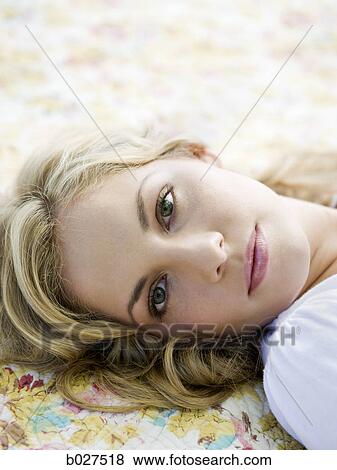 Stock Photo - woman lying on a floral print blanket. Fotosearch