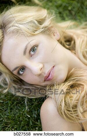 woman lying on the grass looking at the camera View Large Photo Image Stock Photo - woman lying on the grass looking at the camera. Fotosearch