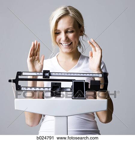 Stock Image - woman on a scale. Fotosearch