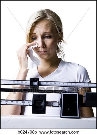 Stock Image - woman on a scale. Fotosearch