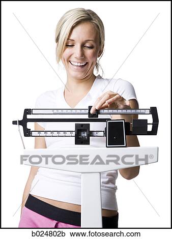 Stock Image - woman on a scale. Fotosearch