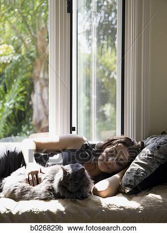 woman on a window bench with her cat View Large Photo Image Stock Image - woman on a window bench with her cat. Fotosearch
