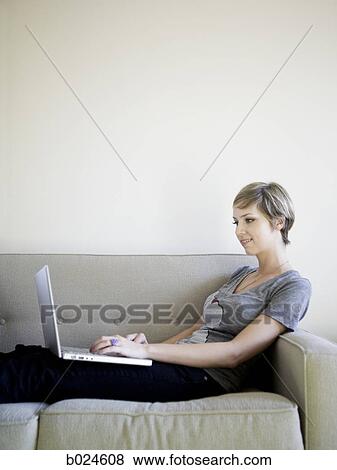 woman on the couch using a laptop View Large Photo Image Stock Photo - woman on the couch using a laptop. Fotosearch