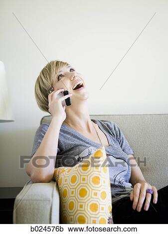 Stock Image - woman on the couch using cell phone. Fotosearch