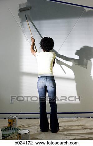 Stock Image - woman painting a room. Fotosearch