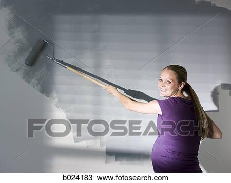 Stock Image - woman painting a room. Fotosearch