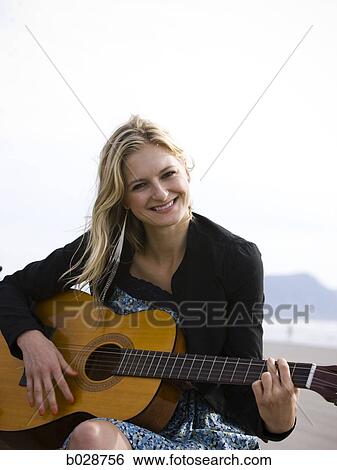 woman playing the guitar at the beach View Large Photo Image Stock Photograph - woman playing the guitar at the beach. Fotosearch