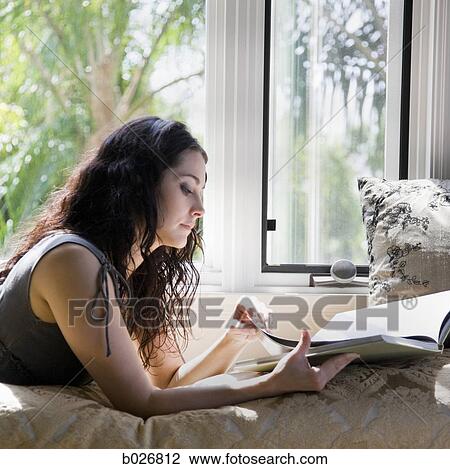 woman reading on a window bench View Large Photo Image Stock Image - woman reading on a window bench. Fotosearch