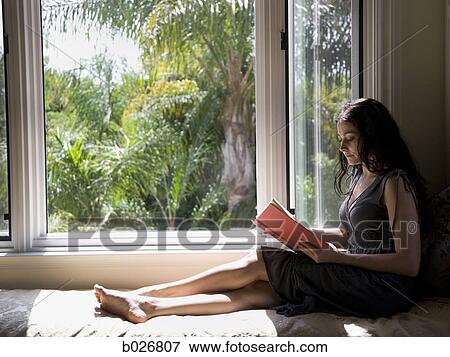 woman reading on a window bench View Large Photo Image Stock Photo - woman reading on a window bench. Fotosearch