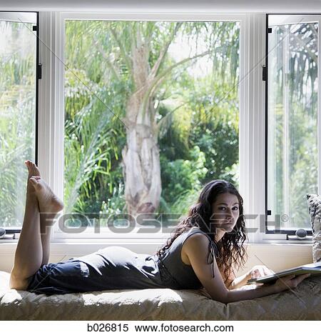 woman reading on a window bench View Large Photo Image Stock Photography - woman reading on a window bench. Fotosearch