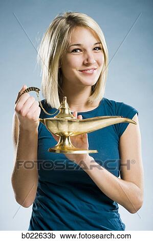 Stock Image - woman rubbing a magic lamp. Fotosearch