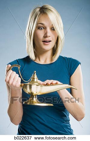 Stock Photo - woman rubbing a magic lamp. Fotosearch