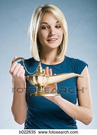 Stock Photography - woman rubbing a magic lamp. Fotosearch