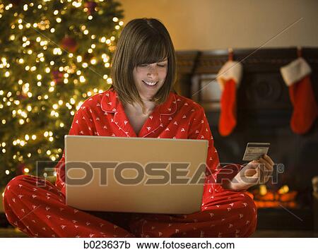Stock Image - woman shopping online at christmas. Fotosearch