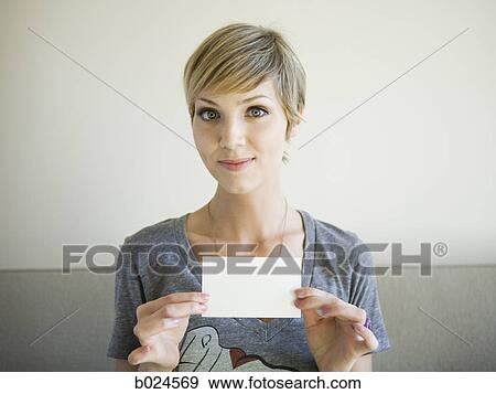 woman sitting on a couch holding up an envelope View Large Photo Image Stock Photo - woman sitting on a couch holding up an envelope. Fotosearch