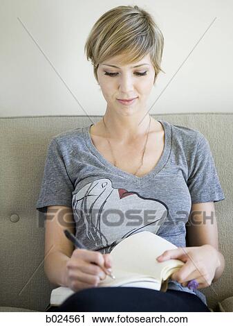 woman sitting on a couch writing in a journal View Large Photo Image Stock Image - woman sitting on a couch writing in a journal. Fotosearch