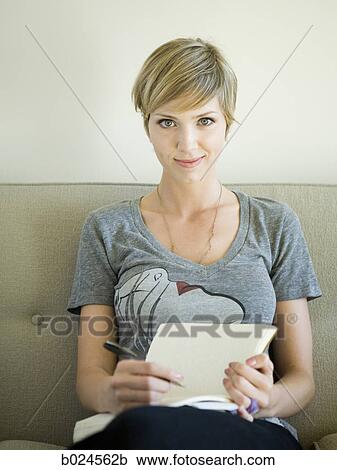 woman sitting on a couch writing in a journal View Large Photo Image Stock Image - woman sitting on a couch writing in a journal. Fotosearch