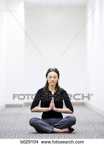woman sitting on the floor in her workplace meditating View Large Photo Image Picture - woman sitting on the floor in her workplace meditating. Fotosearch