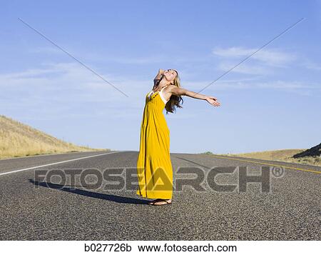 Stock Image - woman standing in the middle of the road. Fotosearch