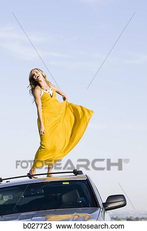 woman standing on the roof of her car on the side of the road View Large Photo Image Stock Image - woman standing on the roof of her car on the side of the road. Fotosearch