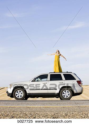 woman standing on the roof of her car on the side of the road View Large Photo Image Stock Photography - woman standing on the roof of her car on the side of the road. Fotosearch
