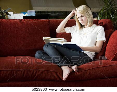 woman studying on a red sofa View Large Photo Image Stock Image - woman studying on a red sofa. Fotosearch
