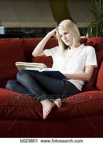 woman studying on a red sofa View Large Photo Image Stock Image - woman studying on a red sofa. Fotosearch