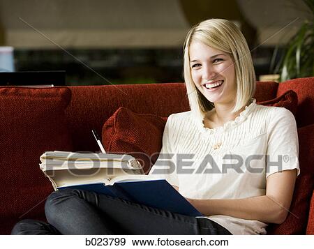 woman studying on a red sofa View Large Photo Image Stock Photo - woman studying on a red sofa. Fotosearch