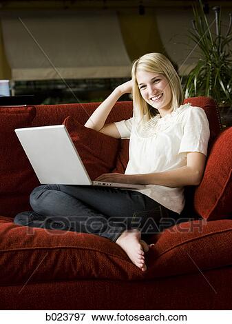 woman using a laptop on a sofa View Large Photo Image Stock Photo - woman using a laptop on a sofa. Fotosearch