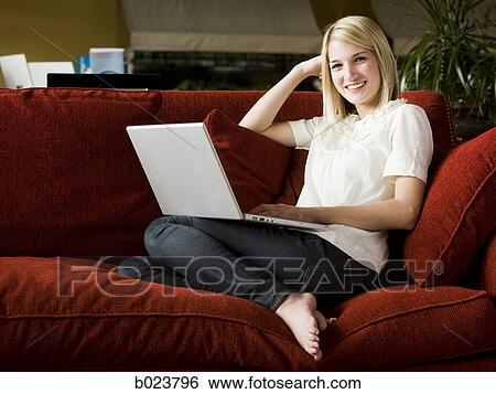 woman using a laptop on a sofa View Large Photo Image Stock Photograph - woman using a laptop on a sofa. Fotosearch