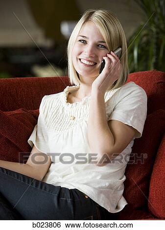 woman using her cell phone on a red sofa View Large Photo Image Stock Photograph - woman using her cell phone on a red sofa. Fotosearch