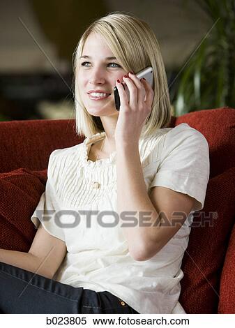 woman using her cell phone on a red sofa View Large Photo Image Stock Photography - woman using her cell phone on a red sofa. Fotosearch