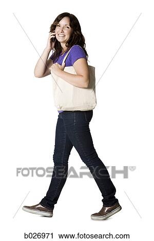 woman walking with a cell phone View Large Photo Image Stock Image - woman walking with a cell phone. Fotosearch