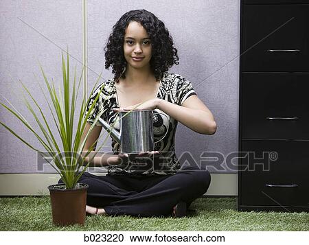 woman watering a plant in her "green" office View Large Photo Image Stock Image - woman watering a plant in her "green" office. Fotosearch